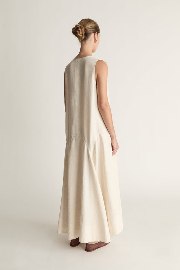 Woman wearing a long beige dress on a white background