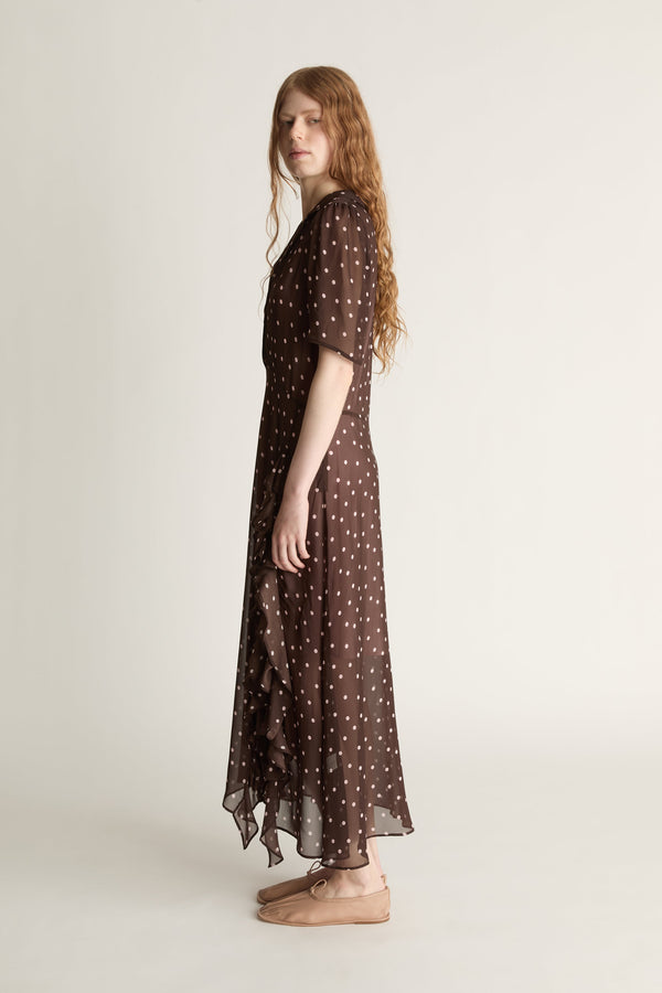 Woman wearing a brown polka dot dress on a white background