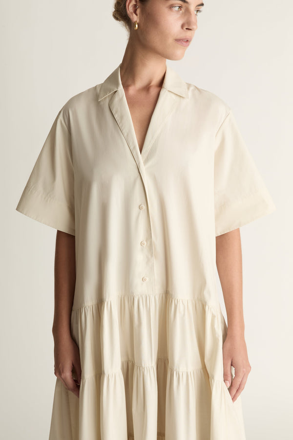 Woman wearing a beige dress against a white background