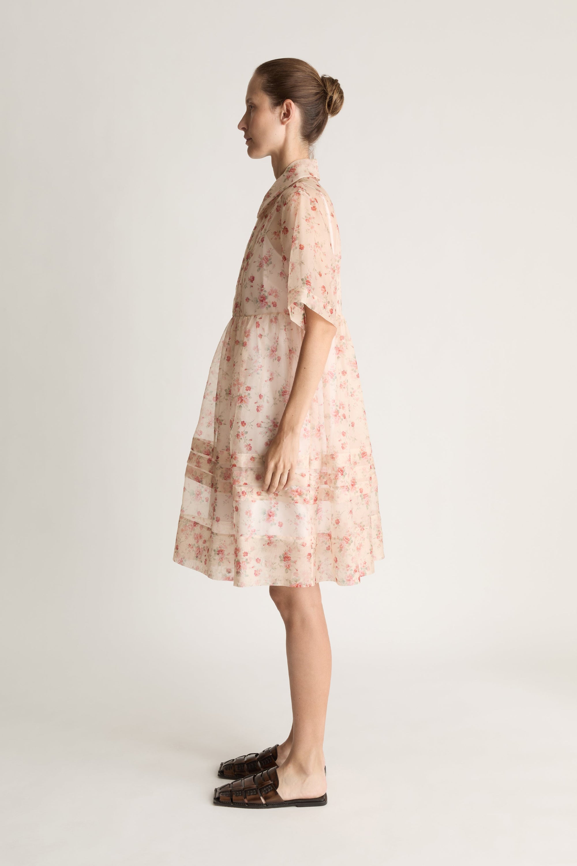 Woman wearing a floral mini dress on a white background