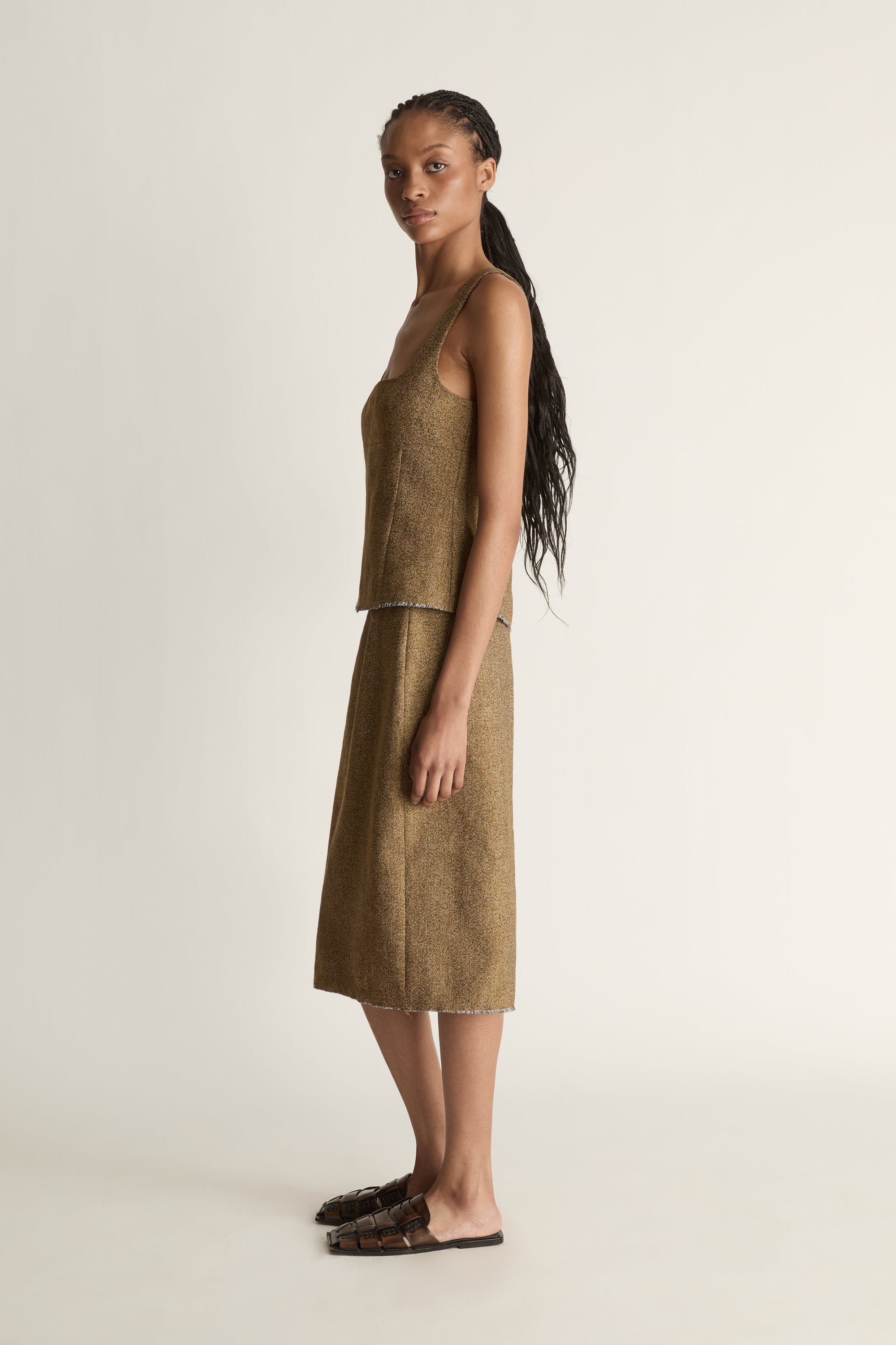Side view of a woman wearing a brown linen wool pencil style skirt