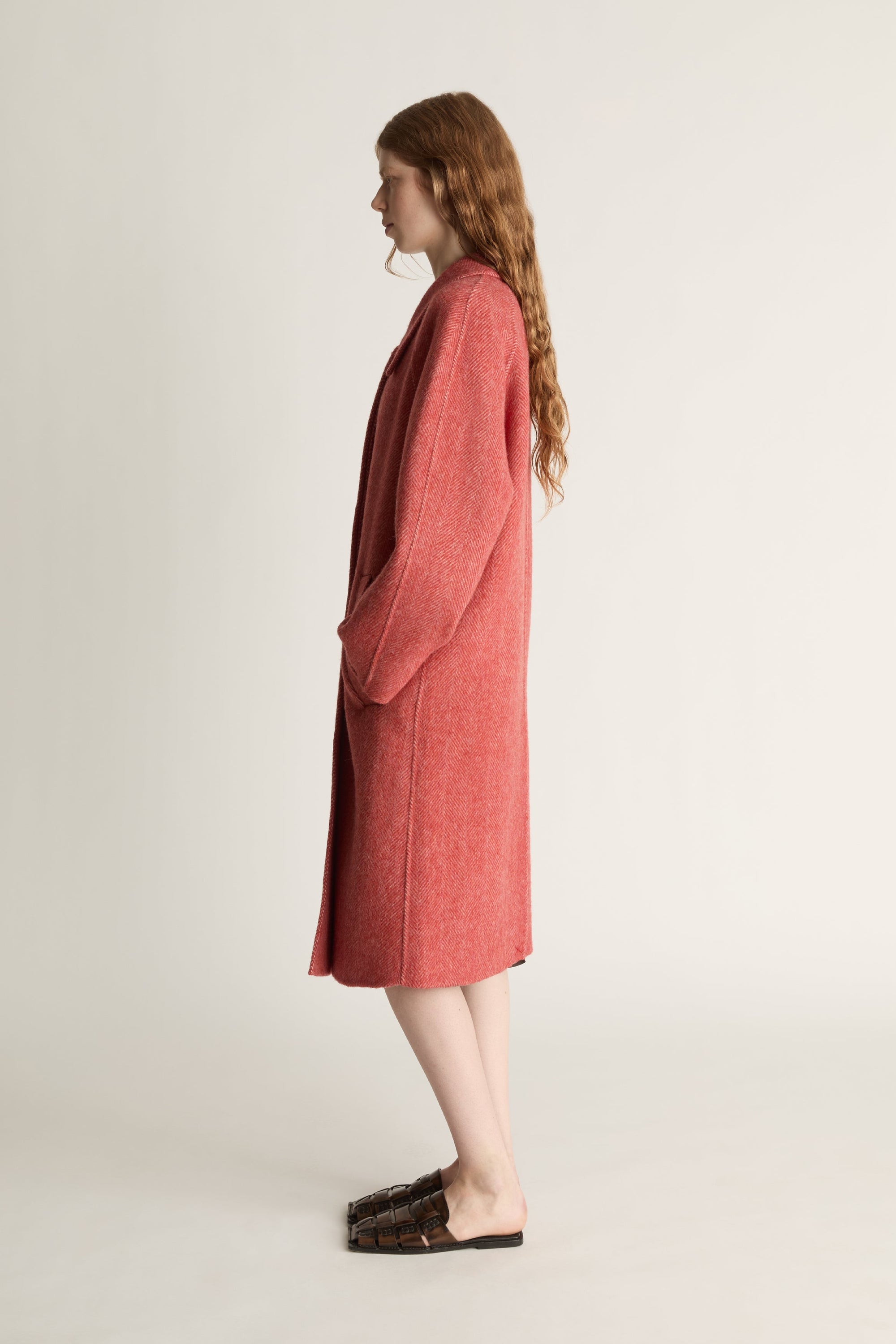 Person wearing a red coat on a plain background