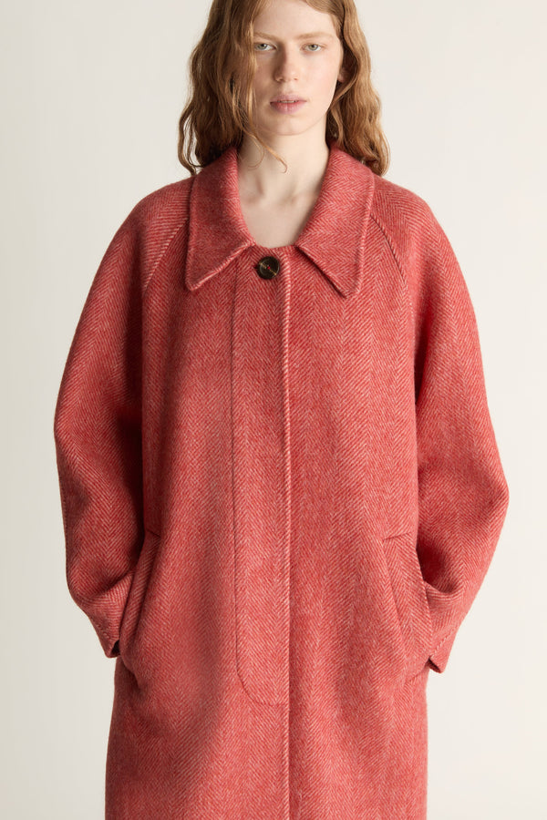 Person wearing a red coat on a plain background