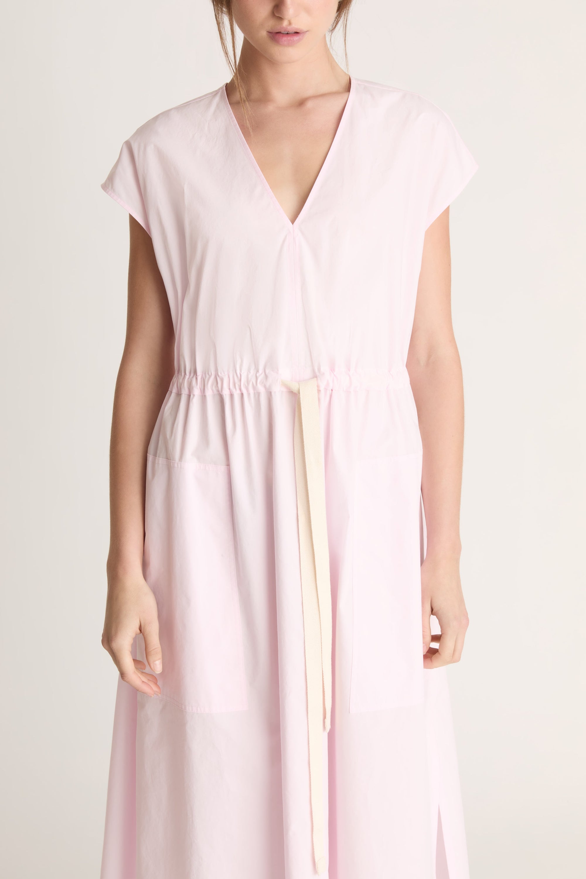 Woman wearing a light pink dress on a white background