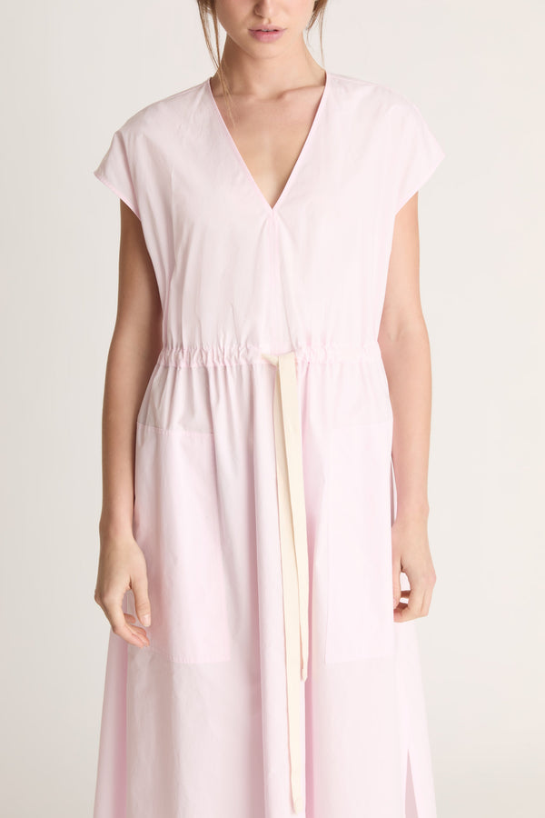 Woman wearing a light pink dress on a white background