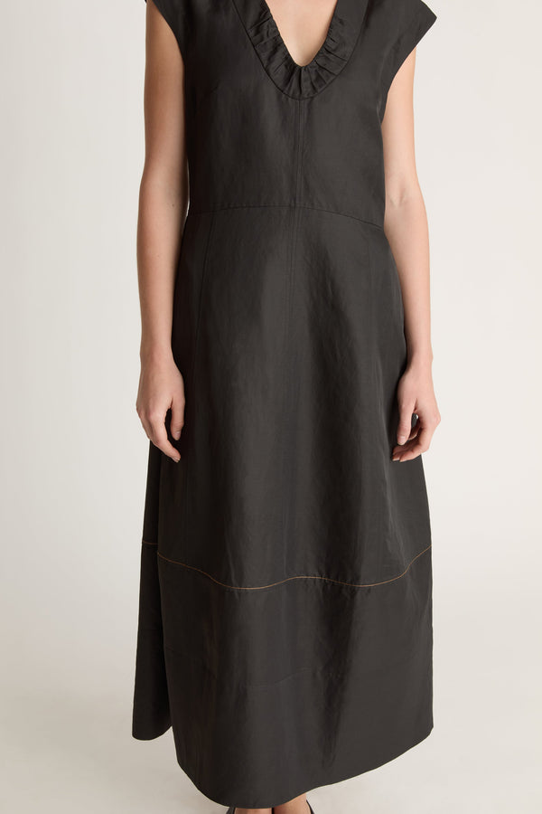 Woman wearing a black  v neck dress on a white background