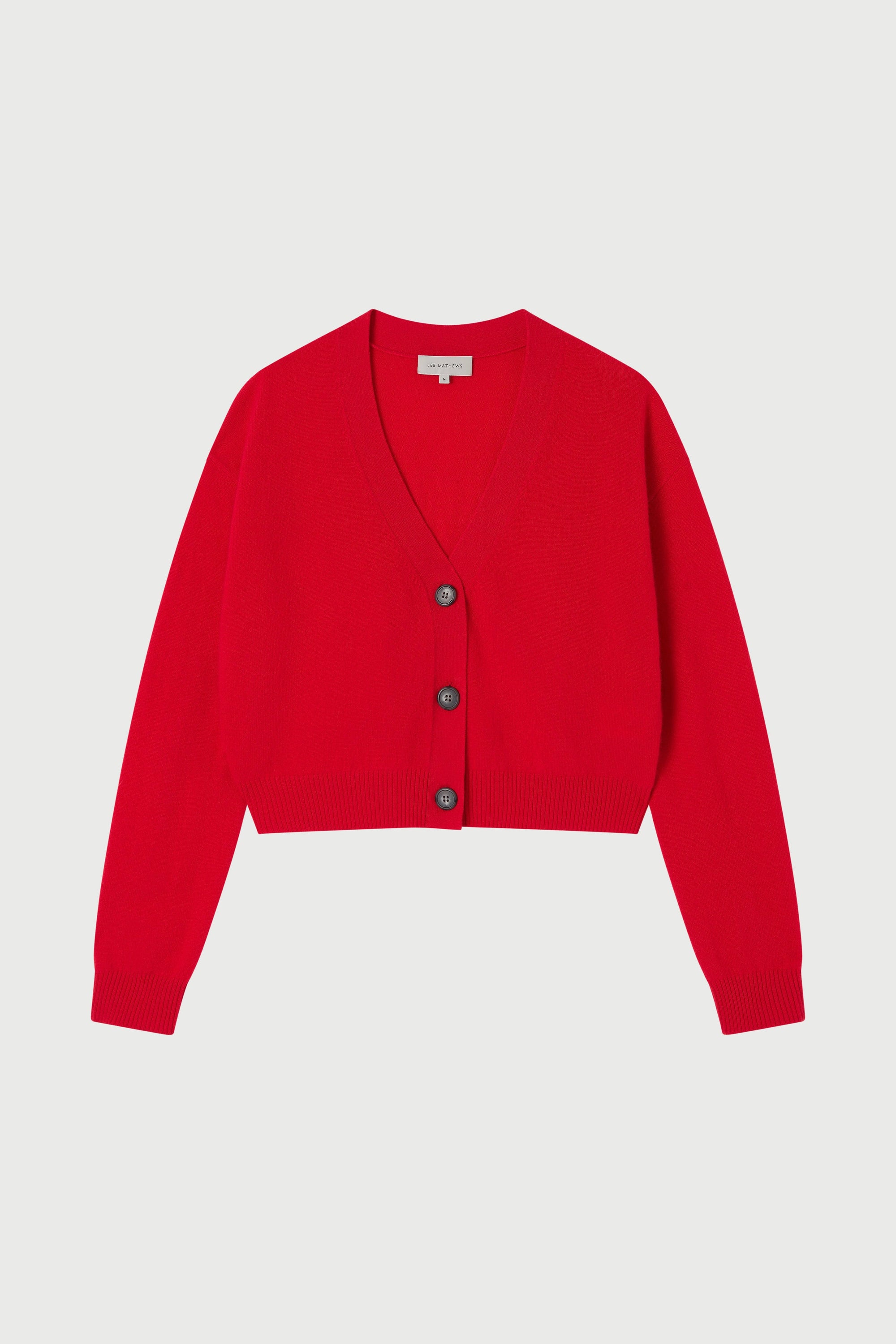 Red cardigan with buttons on a light gray background