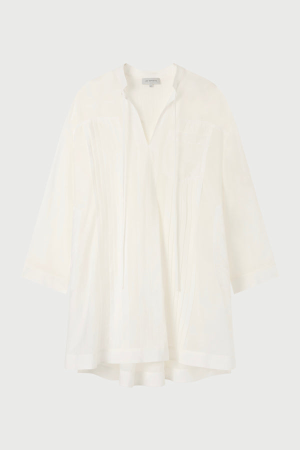 A white tunic against a plain background